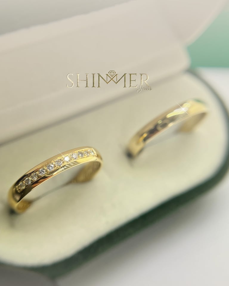 Elegant gold wedding band set with a diamond-encrusted ring in a luxury jewelry gift box.
