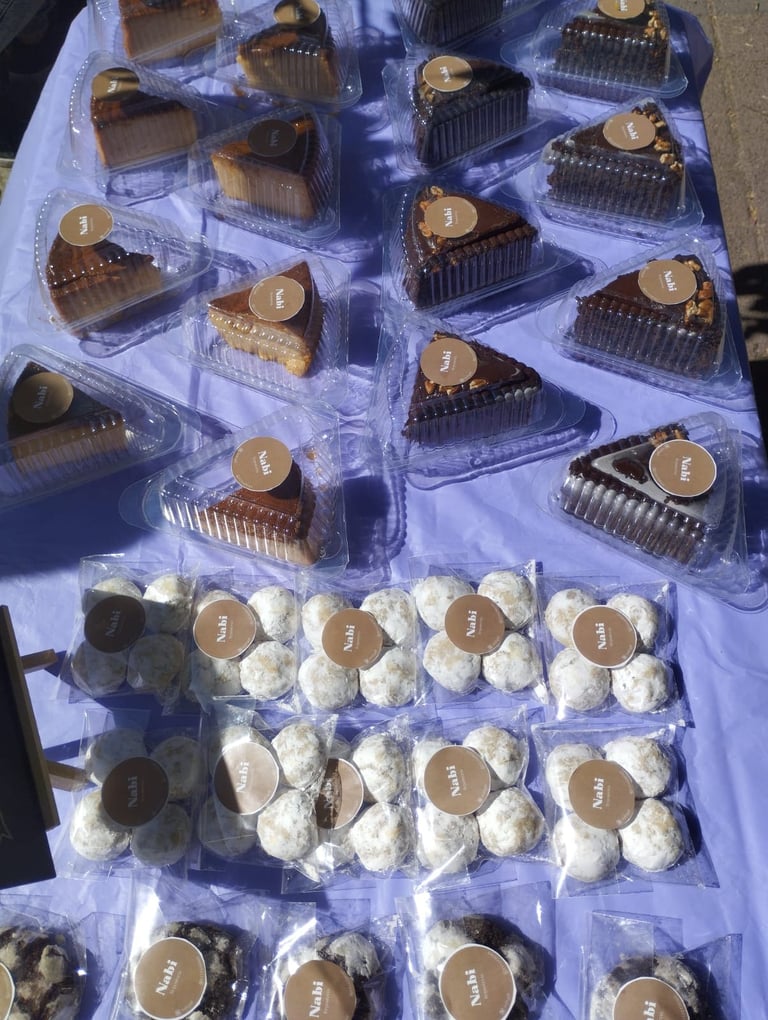 Surtido de rebanadas de pastel gourmet y galletas espolvoreadas con azúcar glass, presentadas en emp