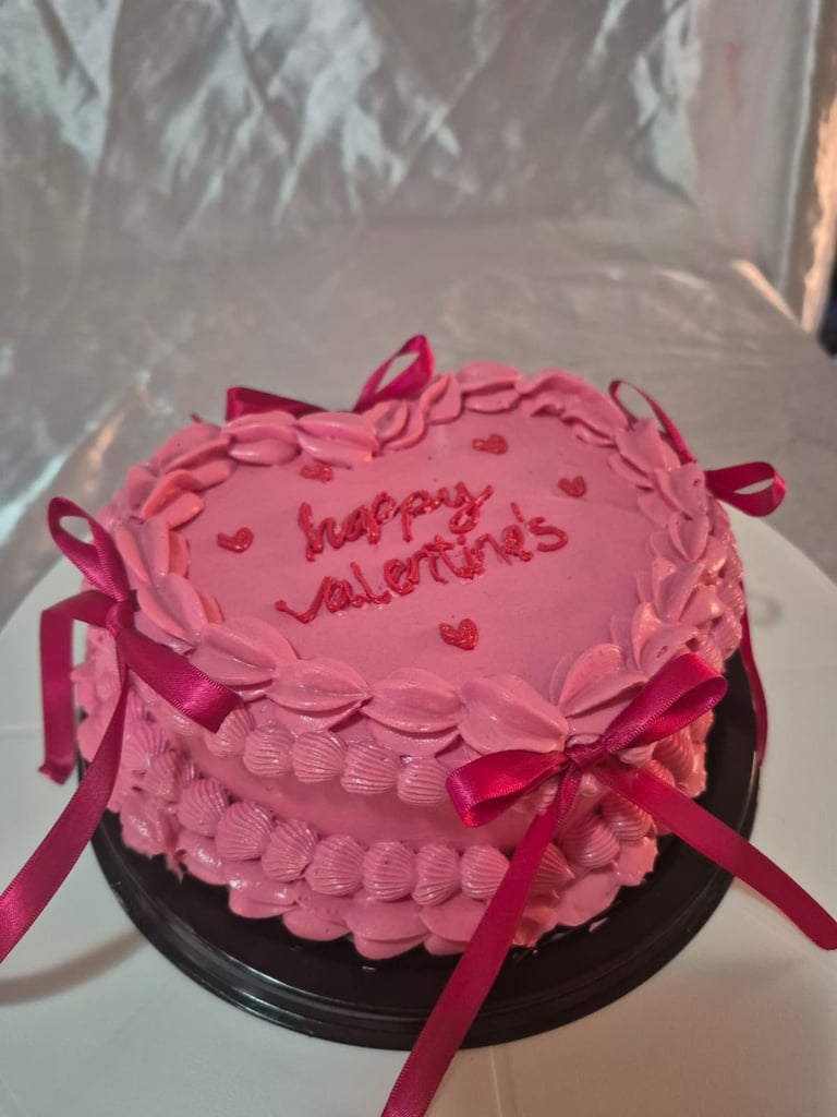 Pastel rosa en forma de corazón con estilo vintage, listones y letras decoradas a mano.