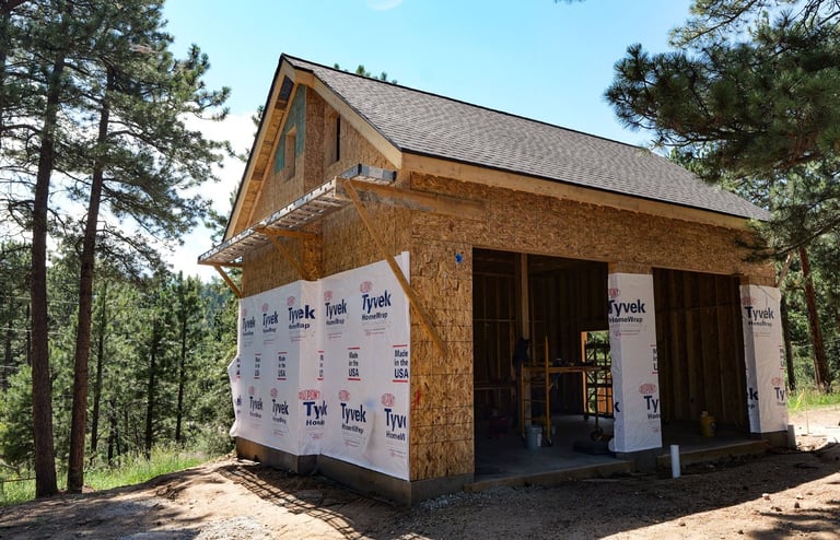 Exterior garage framing with weather-protective house wrap.