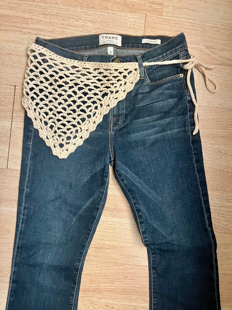 Crochet bandana belt wrapped at waist of a pair of jeans