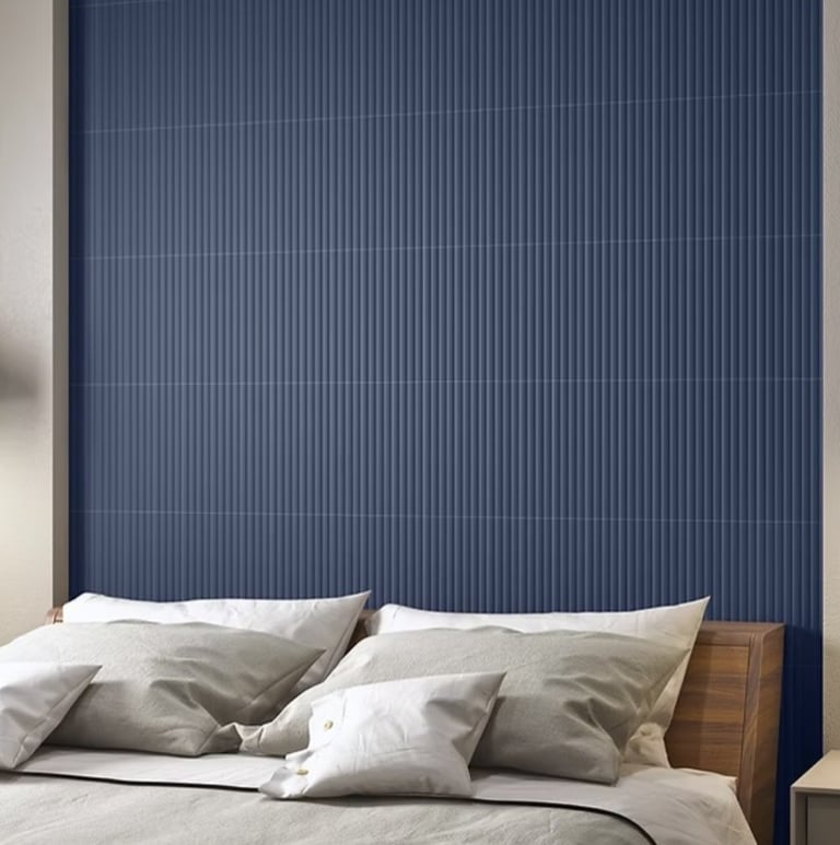 A cozy bedroom scene featuring a stylish blue, textured accent wall.