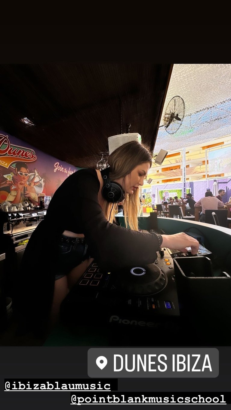 Kat Bendis performing a live electronic music set on Pioneer decks at Dunes Ibiza beach club.