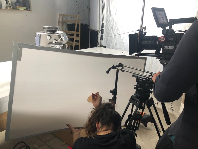 women holding light bounce board on set