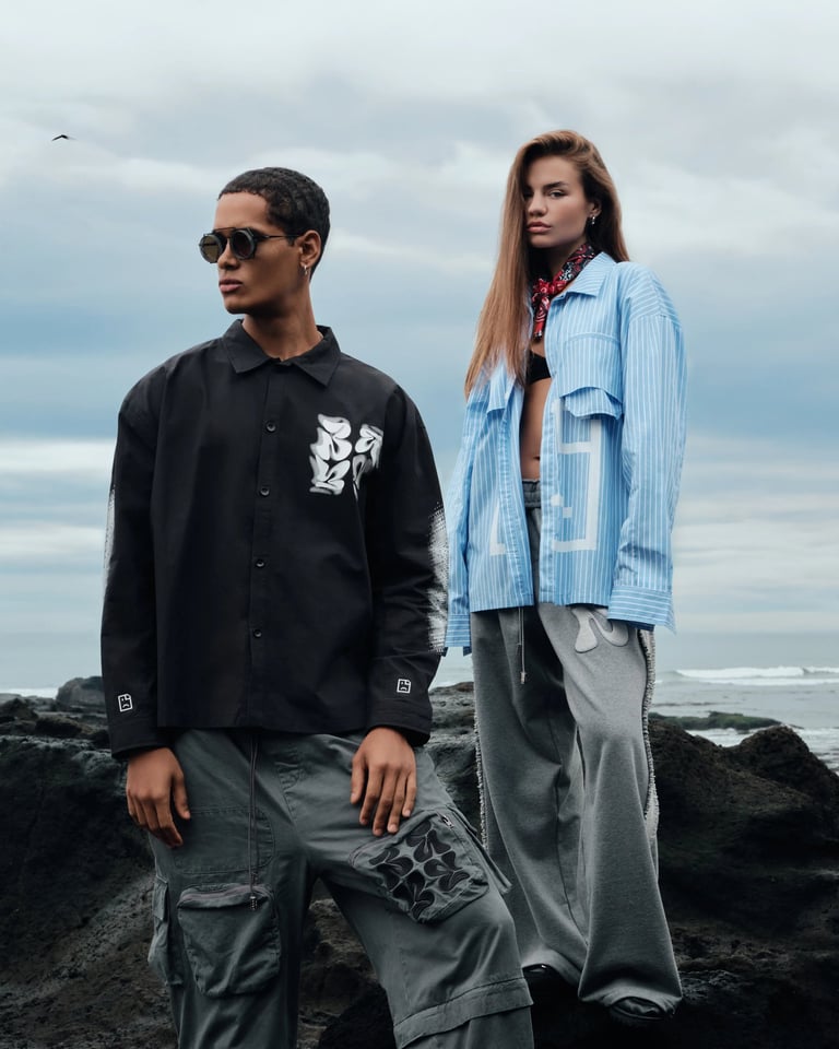 Two models in streetwear posing on volcanic rocks for Break the Cycle Summer 2025 Bali.