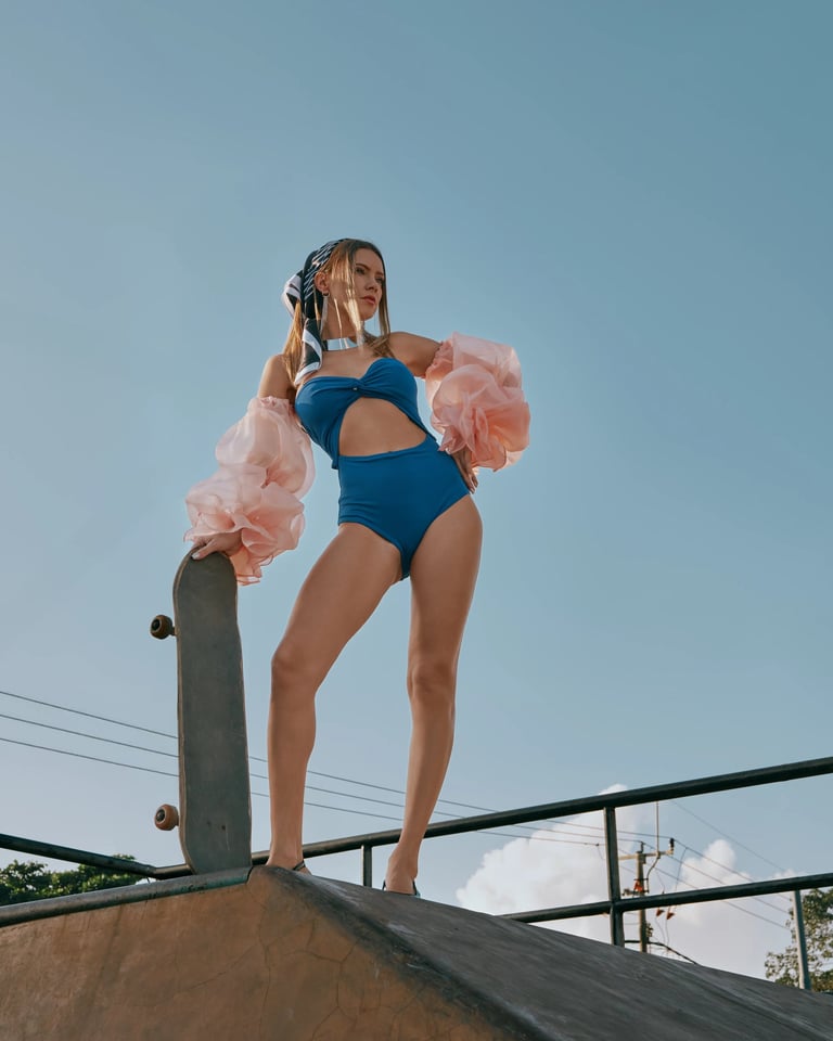 Model in blue swimwear preparing to skate at Bali skatepark for KINI Produksi fashion editorial.