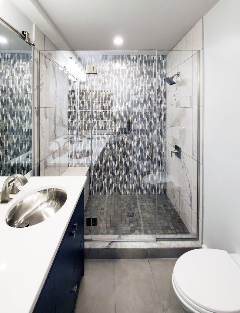 Primary bath renovation, mosaic tile shower, navy vanity, marble countertop, Medford MA Greater Boston