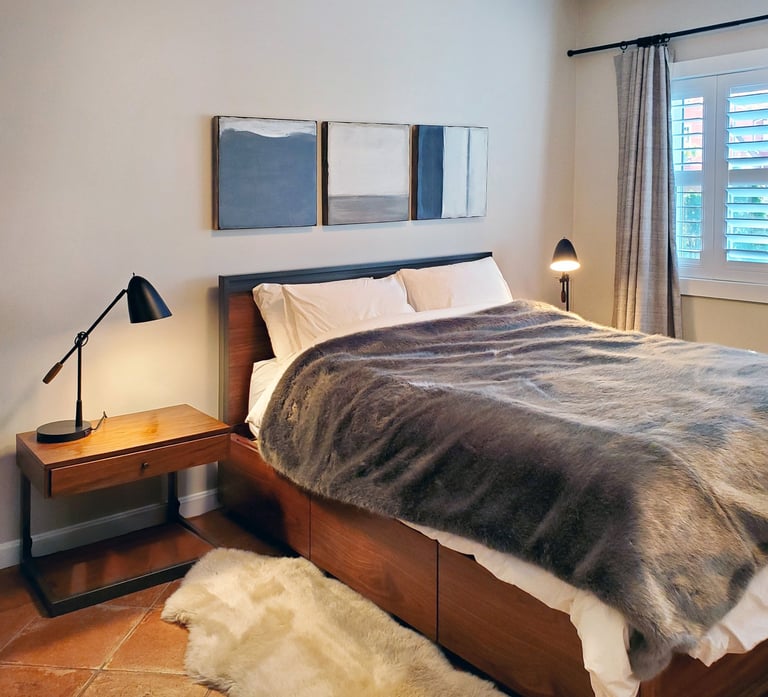 Primary bedroom, walnut bed frame, abstract triptych, cotto tile floor, Medford MA, Erica Fossati Design