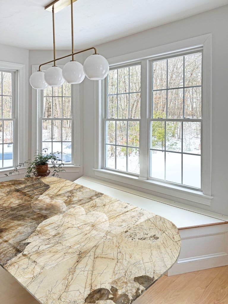 Stone top table, brass globe pendant, white trim, interior renovation Lancaster MA, Erica Fossati Design