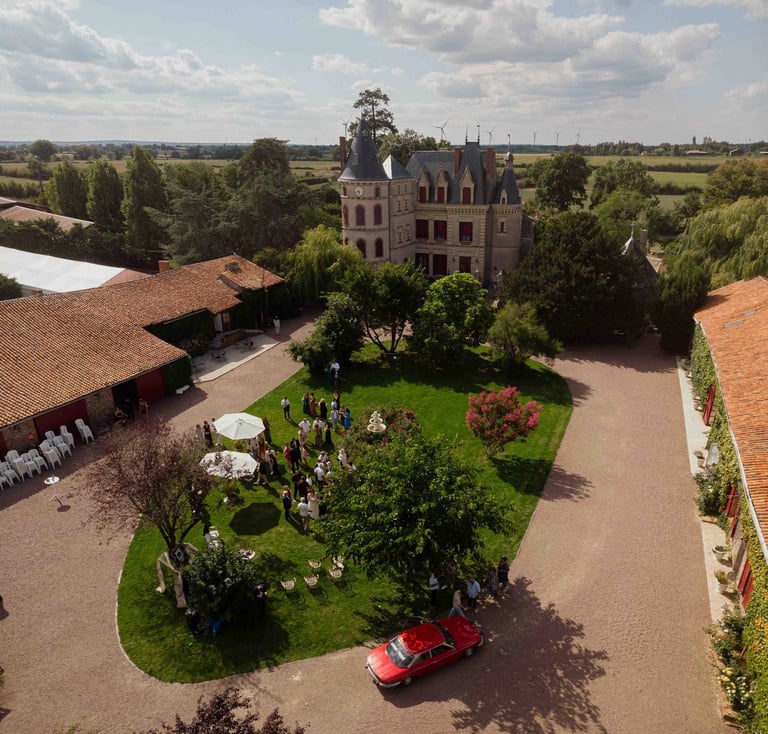 Photo de mariage au drone Vue aérienne du Château des Landes et de ses invités dans le jardin