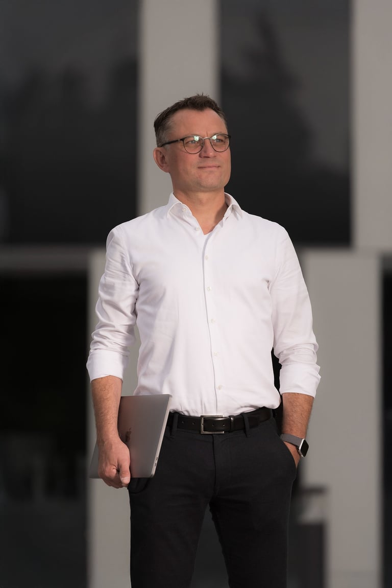 Unternehmer mit Laptop vor moderner Architektur in Oranienburg – Businessportrait bei Abendlicht