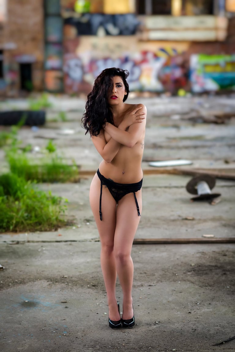 Boudoir-Aufnahme einer Frau in schwarzer Lingerie, die in einer verlassenen Industriehalle posiert; atmosphärisches Fineart-F