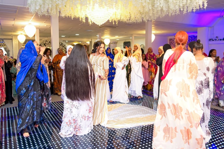 Happy Somalian bride dancing with bridesmaids, all dressed in traditional white & gold dresses, light & airy photo