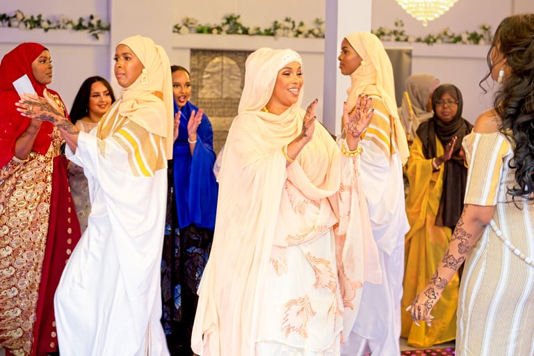 Happy Somalian bride dancing with aunty, both dressed in traditional dresses, light & airy photo