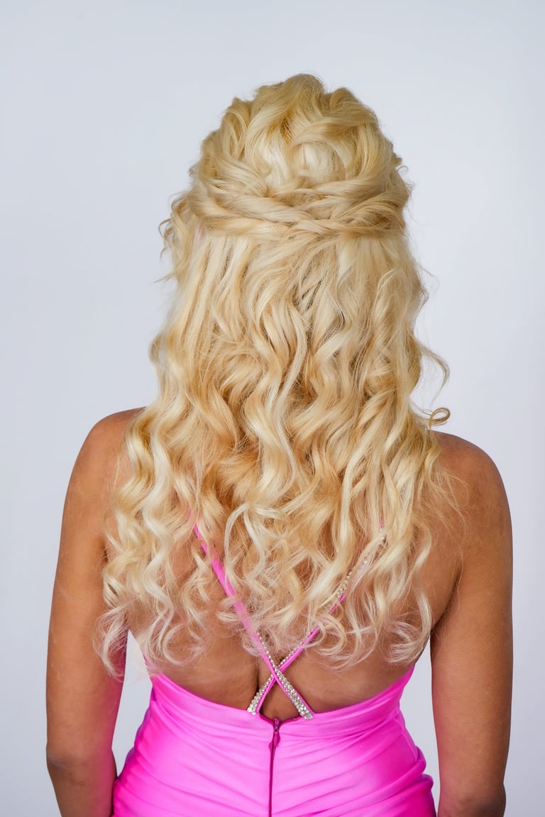 Woman with long blonde hair styled in curly half up half down hairstyle, voluminous waves for wedding or formal event look.