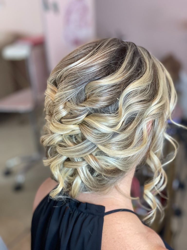 Blonde bride with curly textured updo hairstyle featuring soft romantic waves, elegant look for wedding or formal event.