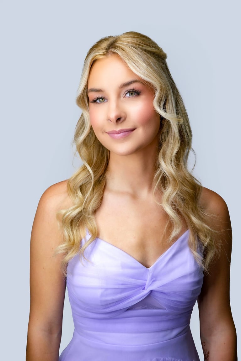 Bridesmaid with soft glam makeup and loose blonde curls, wearing a lilac dress with sweetheart neckline for a wedding.