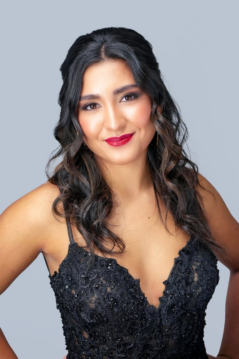 Brunette woman with glam waves hairstyle wearing black lace dress, bold red lipstick, and elegant soft-glam evening makeup.