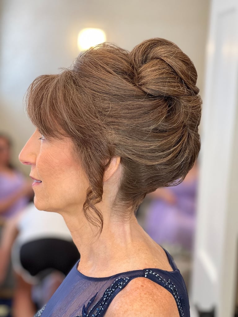 Mother of the bride with voluminous French twist updo hairstyle and side bangs, elegant look for wedding day celebration.