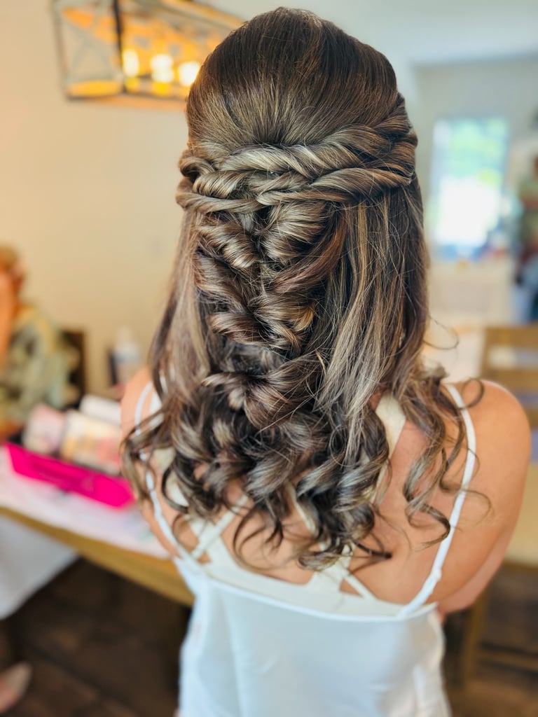 Bride with brown hair styled in twisted half up half down curls, romantic wedding hairstyle with volume and elegant detail.