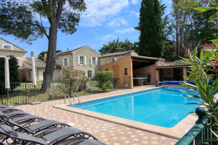 View of the pool and Provençal mas with sunbeds and lush garden, perfect for relaxing holiday in the mas