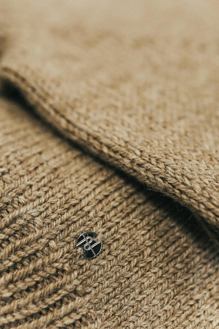 un pull en maille beige avec un insert en metal