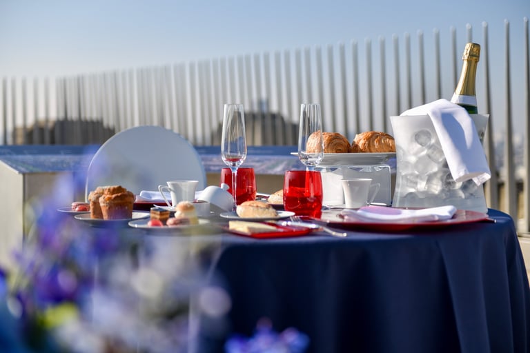 Une table est dressée pour un petit déjeuner haut de gamme, avec du champagne et des fleurs