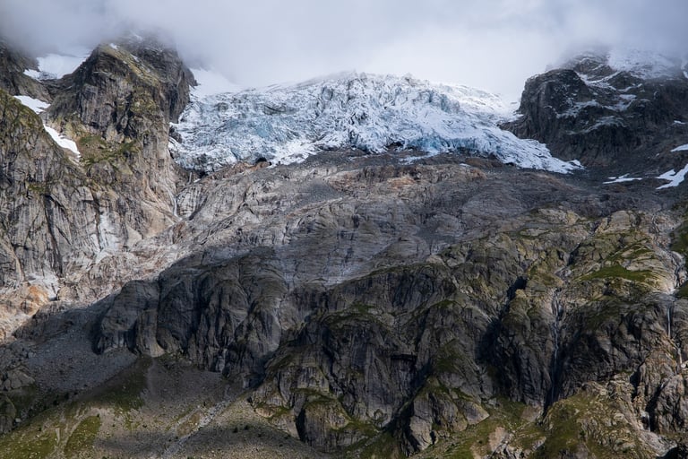 Montagne e ghiacciaio alpino sovrastato da nuvole