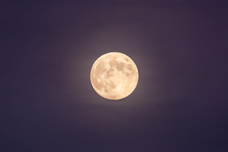 Luna piena con cielo roseo e leggera foschia