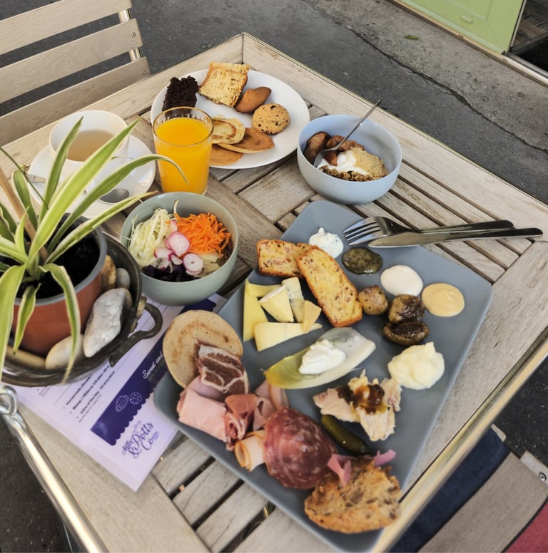 Full brunch spread on the terrace at Mlle & Potts Co in Bordeaux: charcuterie, cheese board, pastrie