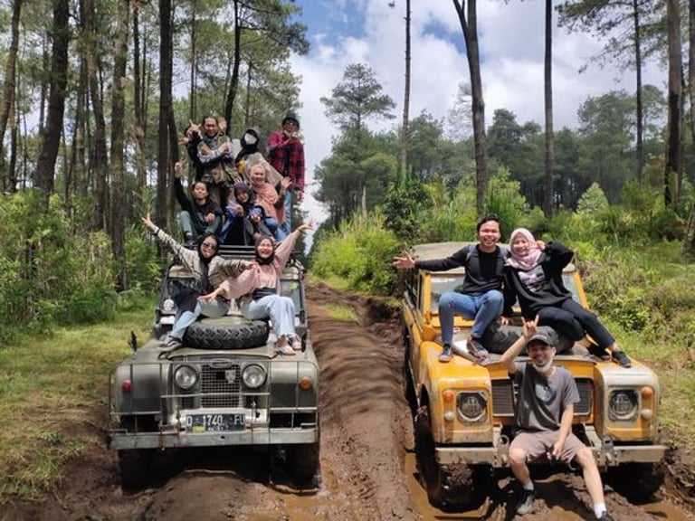 Wisata off road Lembang bersama rombongan di atas jeep 4x4 di tengah hutan pinus, suasana seru dan ceria di jalur tanah