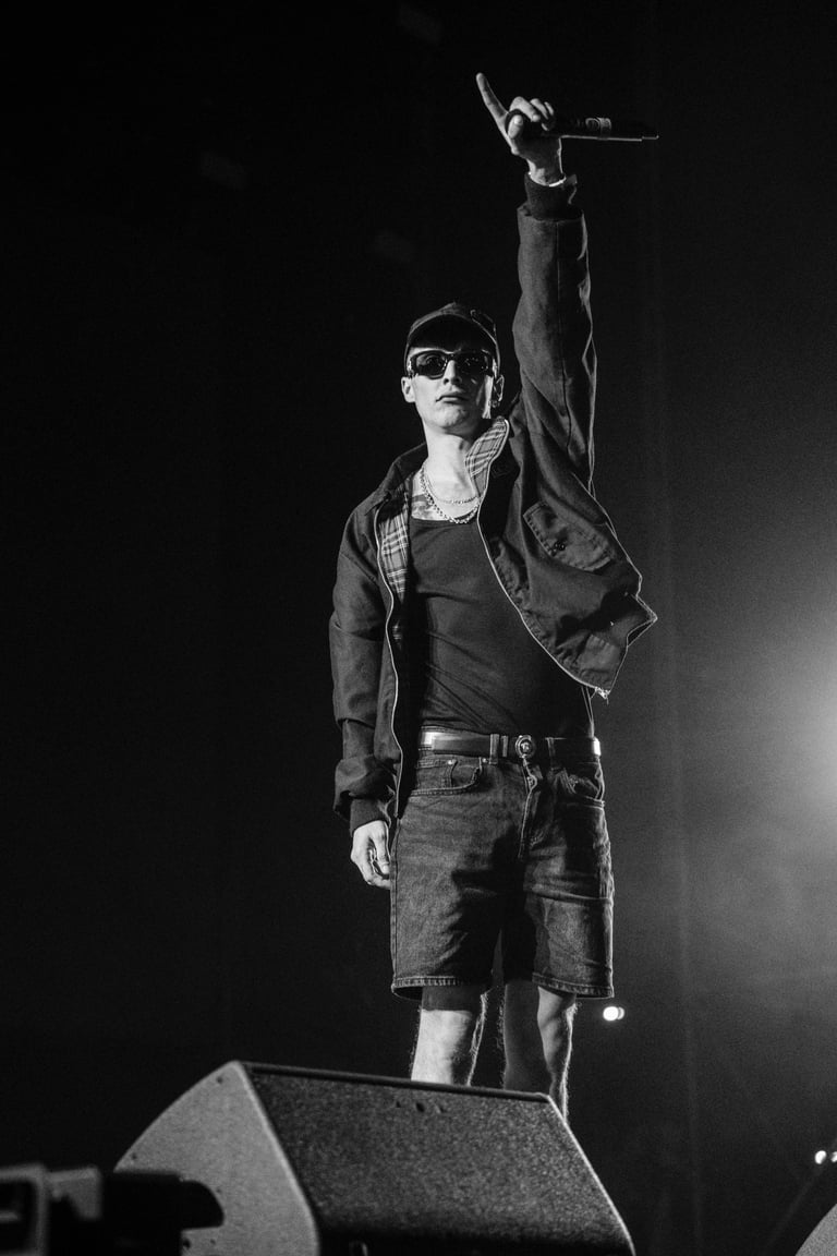 Black and white image of a Ayax & Prok with sunglasses performing on stage with a microphone at SONORAMA RIBERA in Bilbao. Li