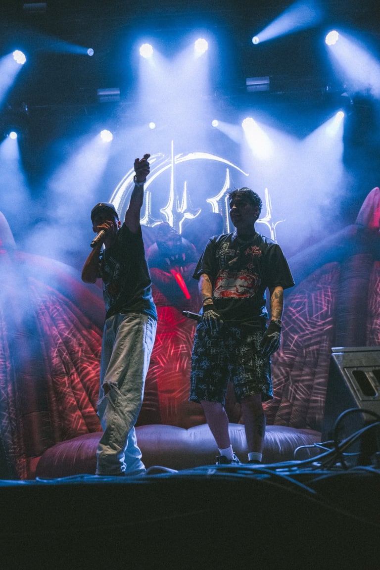 CRO y AYAX Y PROK on stage at Boombastic Festival. Blue stage lights and smoke. Energetic hip-hop performance
