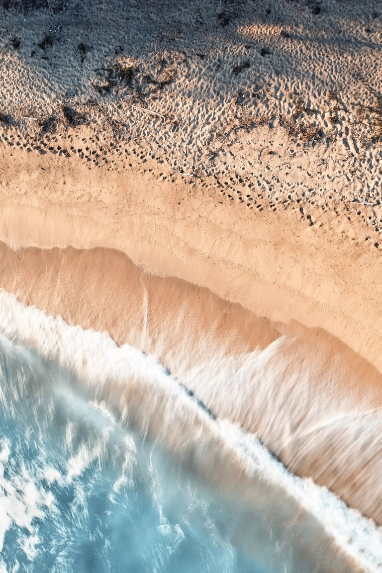 Location: Savinia Beach. Aerial view of waves gently washing onto the sandy shoreline in Mauritius