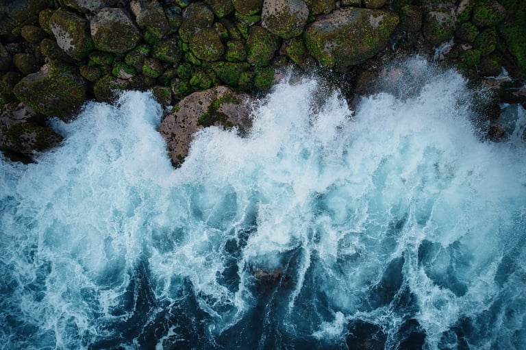 Location: Albion. Aerial view of waves crashing against moss-covered rocks along the coastline in Mauritius