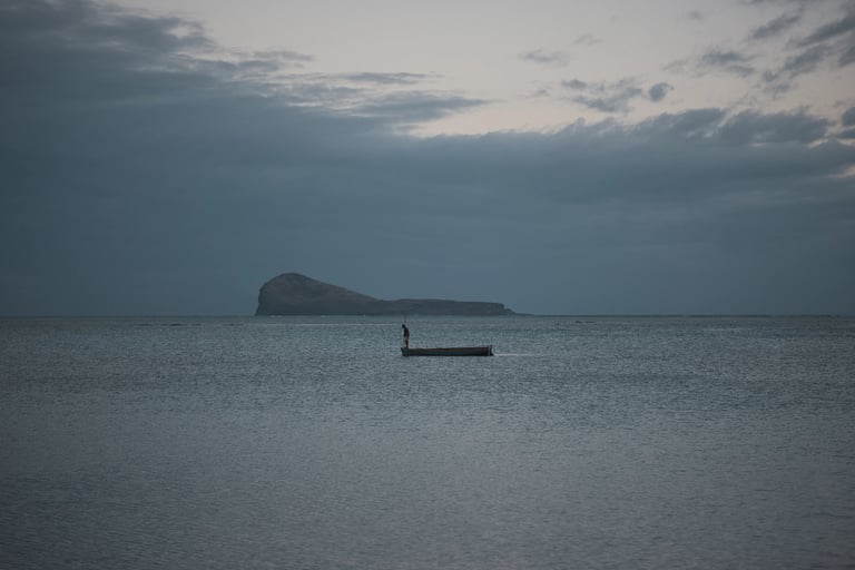 Solitary boat on calm waters with Coin de Mire Island in the background, Mauritius