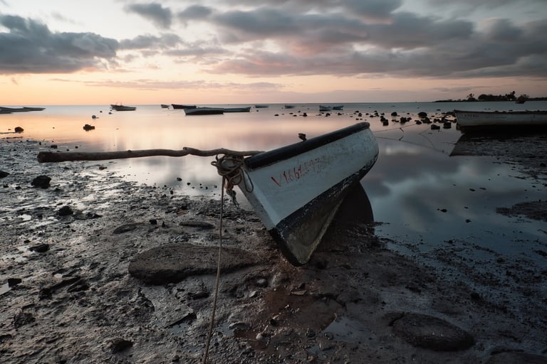Fishing boats at low tide during sunset at Petite Case Noyale in Mauritius.