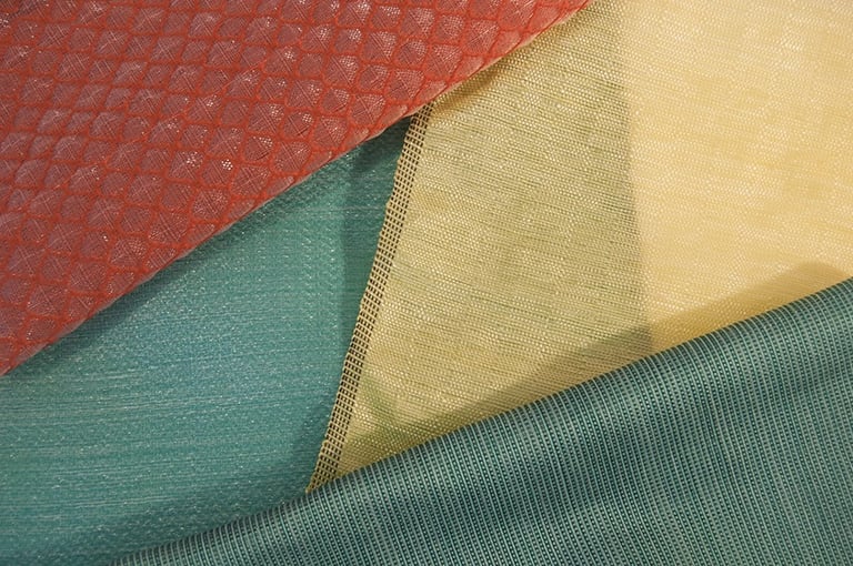 Tissage à la main de fibres plastiques récupérées et upcyclées.