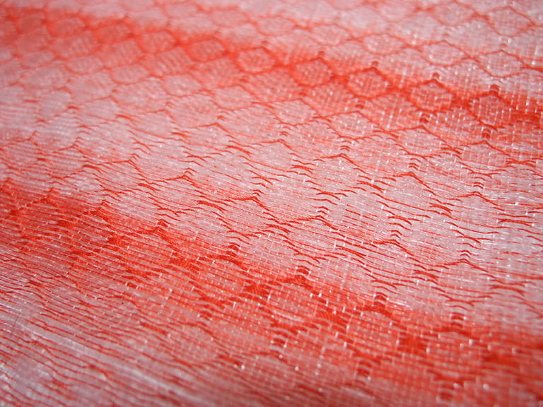 Tissage à la main de fibres plastiques récupérées et upcyclées.