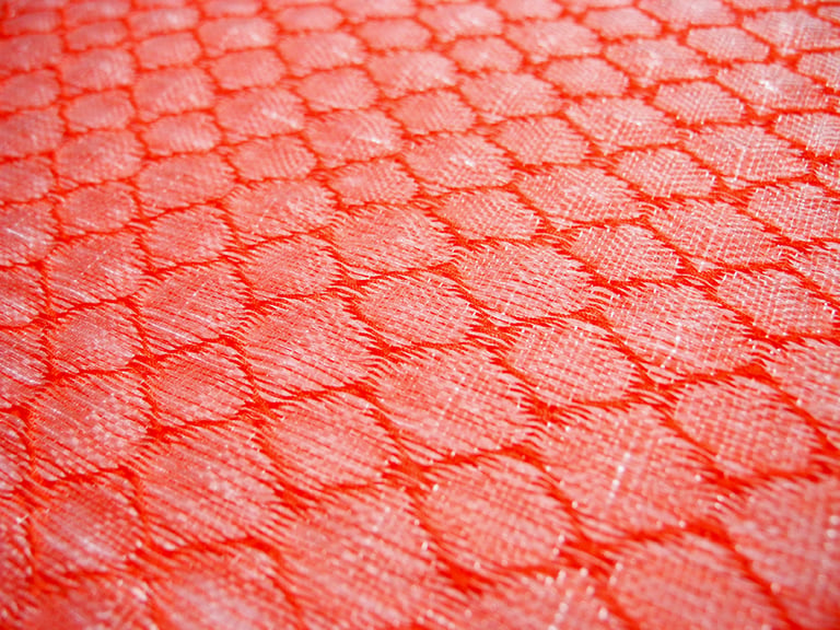 Tissage à la main de fibres plastiques récupérées et upcyclées.
