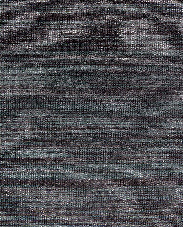 Tissage à la main de fibres plastiques récupérées et upcyclées.