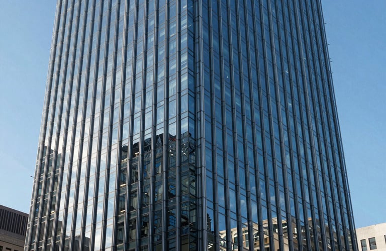Architectural detail of a modern glass skyscraper in a major North American city reflecting a clear blue sky, symbolizing stability and growth.