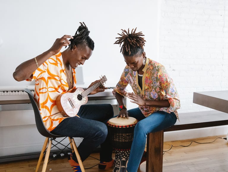  Foto de duas pessoas negras tocando instrumentos musicais em um ambiente interno.
