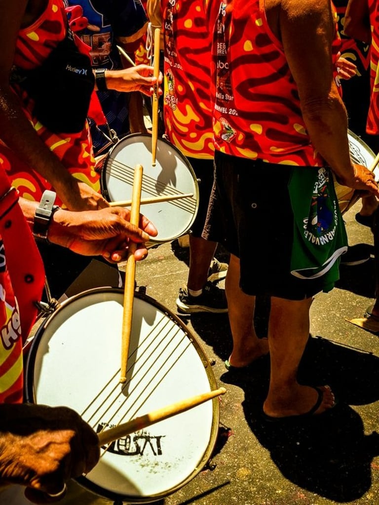 Fotografia de um grupo de pessoas tocando caixas em um bloco de carnaval.