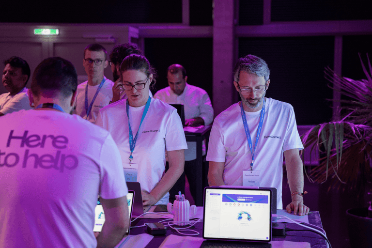 Two Canva employees at a panel event looking at computers.