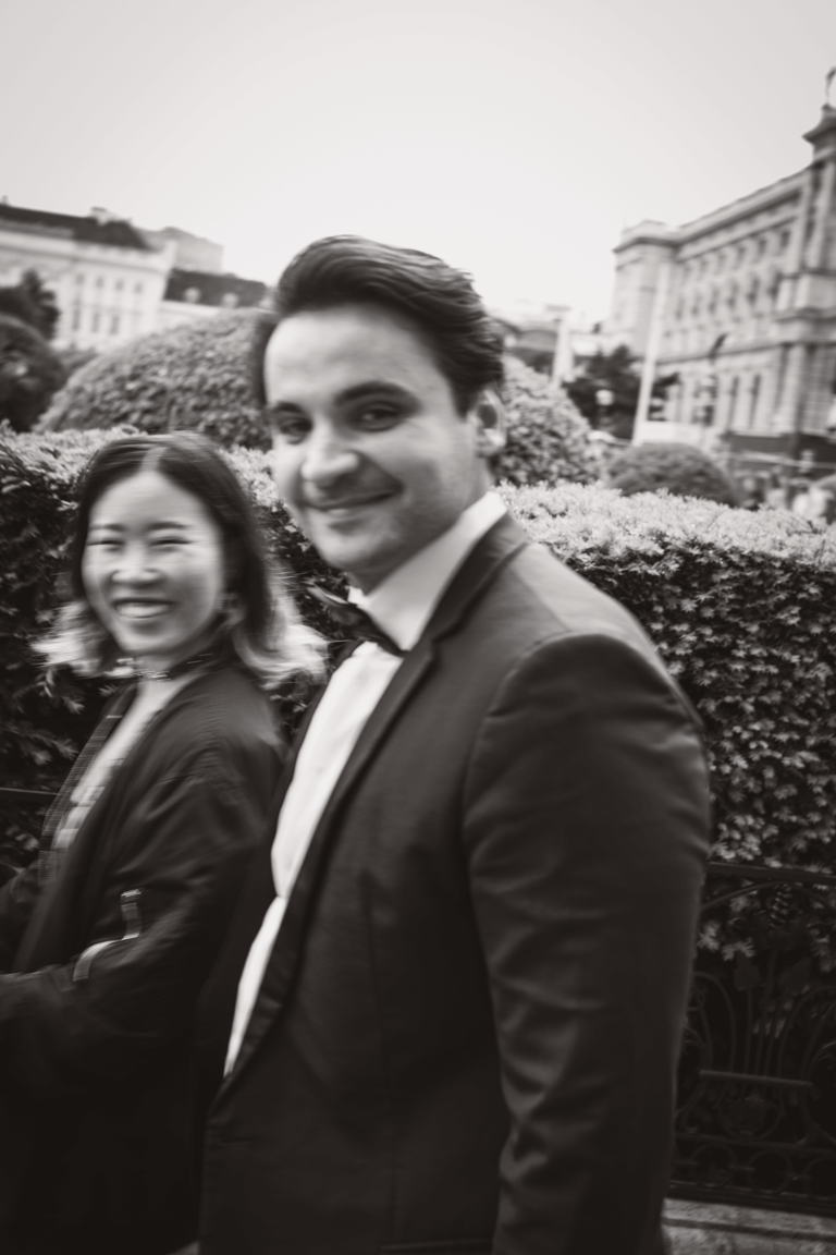 Fancy dressed couple walking in Vienna smiling.