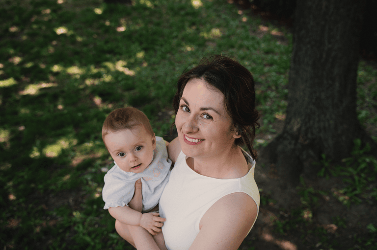 Cinematic portrait of mom holding a baby in the summer in nature on a sunny day.