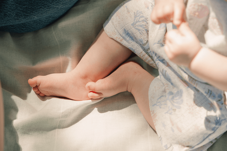 Close up of baby feet in the summer on a blanket on a sunny day.