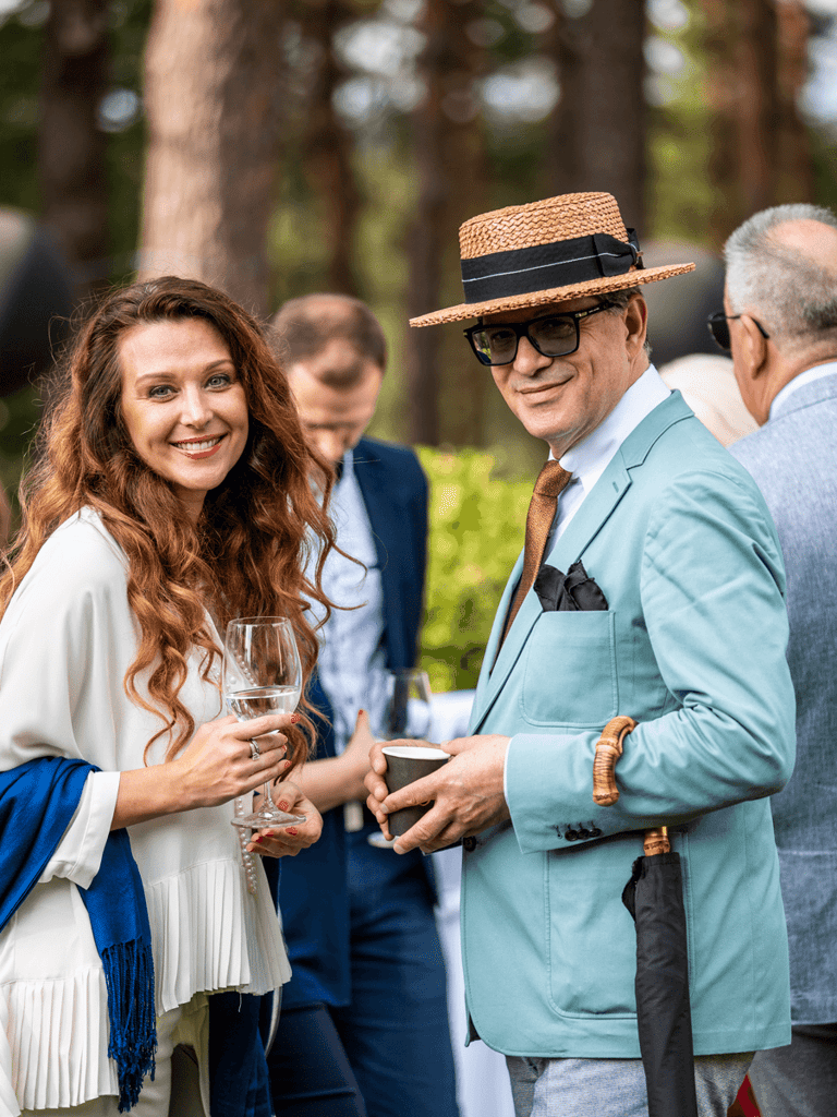 Stylish man and woman at an event looking into the camera and smiling.