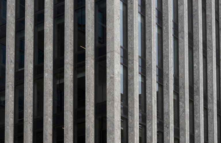 A minimalist architectural detail of a modern building facade featuring strong vertical lines, granite and glass, North American business center.